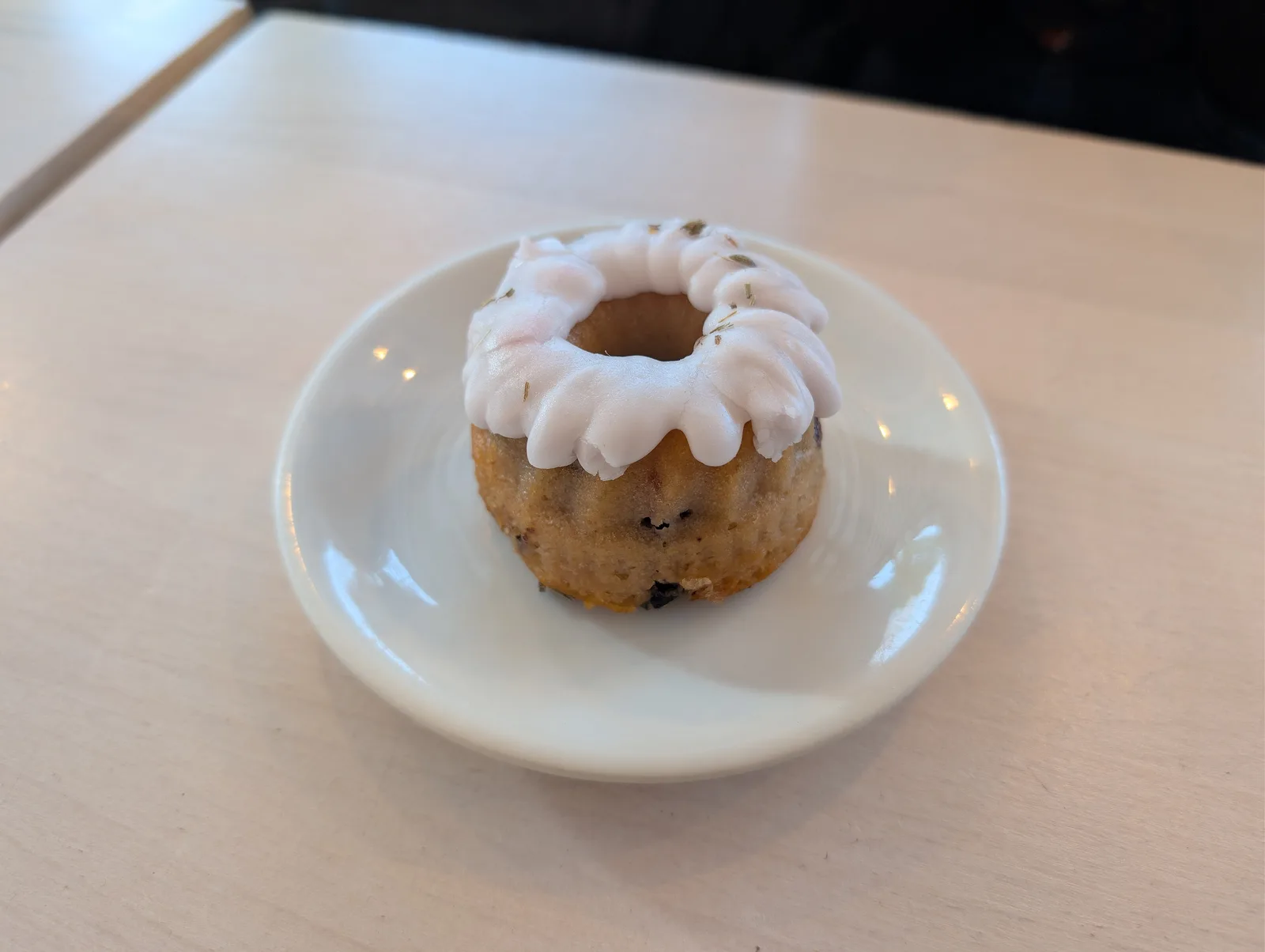 A small glazed blueberry, lemon and lavender bundt cake on a plate