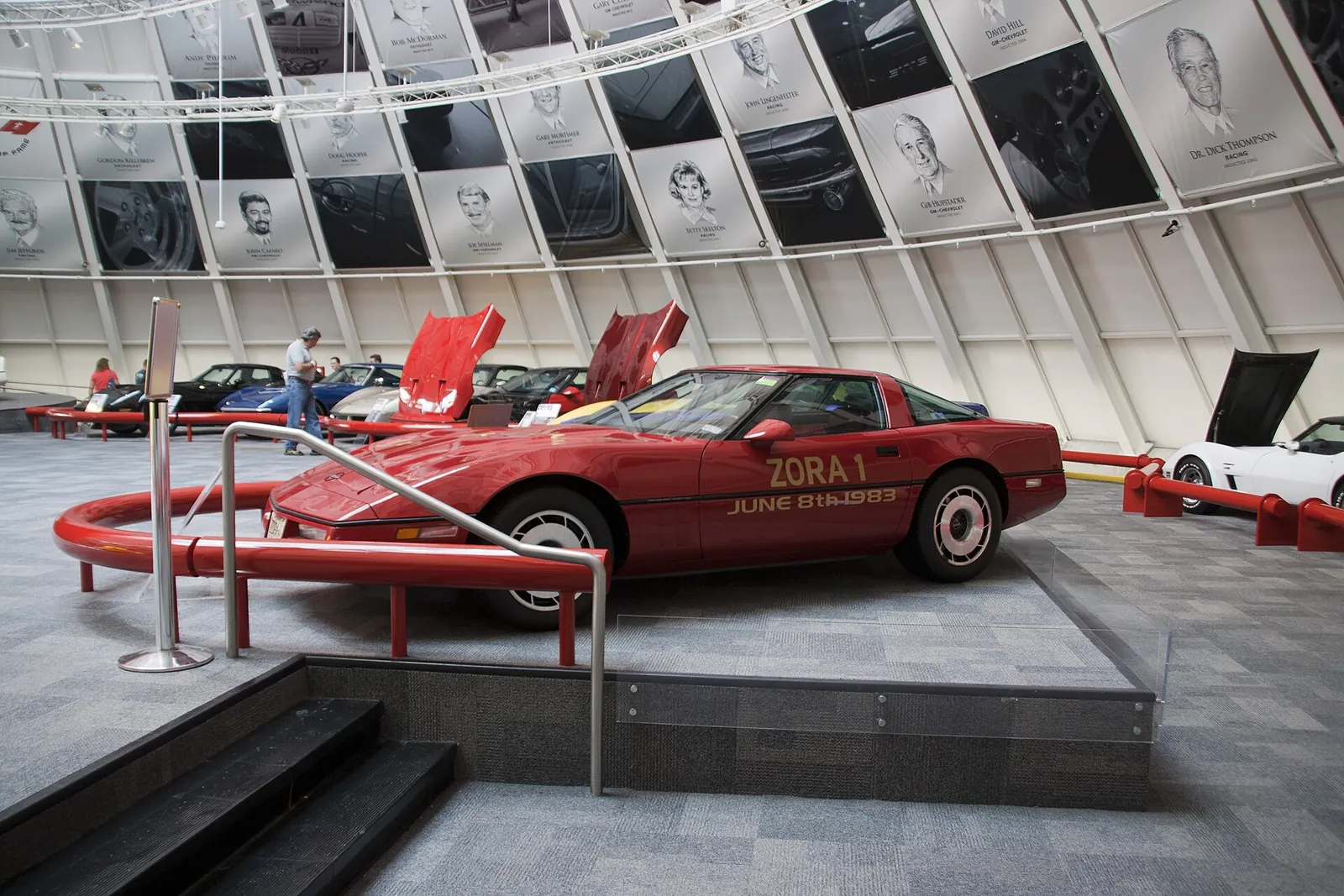 Corvettes on display at the National Corvette Museum in Bowling Green, in a gallery ringed by Corvette Hall of Fame portraits